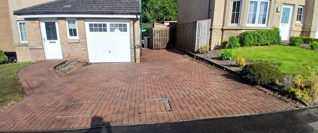 Driveway to a white garage, cleaned by Steam King